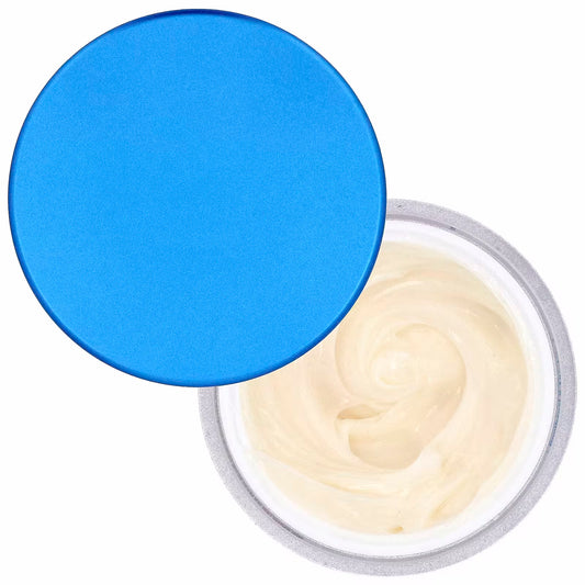 An open round medicube Zero Pore Cream 2.0 50ml filled with a pale cream-colored cream or balm, with a bright blue circular lid leaning against it on a white background.