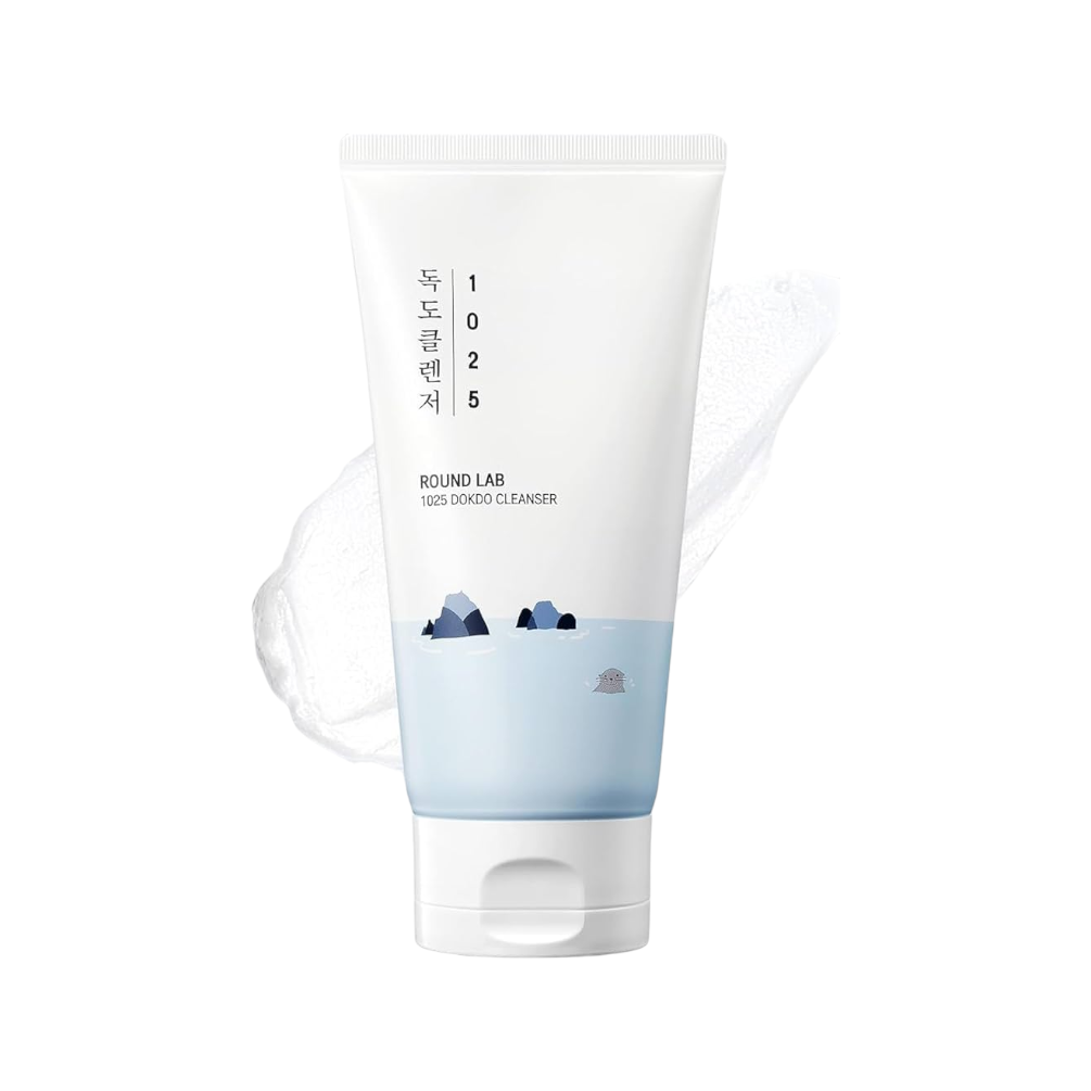 A white squeeze tube of Bound Lab 1025 Korean Cleanser with a light blue lower section and small mountain illustrations, shown on a clean white background with a faint translucent wave graphic behind it.