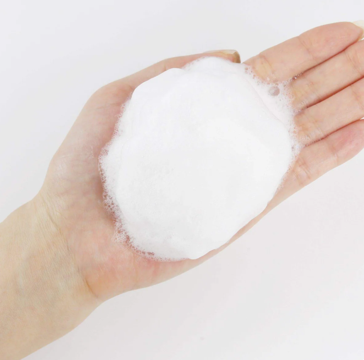 Hand holding a ball of white foam Round Lab 1025 Dokdo Cleanser 150ml
