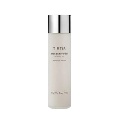A bottle of TIRTIR Milk Skin Toner with a reflective silver cap, set against a clean white background with a soft, translucent heart-shaped liquid splash behind it.