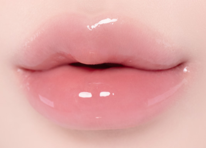 Close-up of glossy pink lips with a smooth, shiny finish and soft rosy skin tones around them.