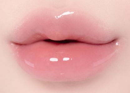 Close-up of glossy pink lips with a smooth, shiny finish and soft rosy skin tones around them.