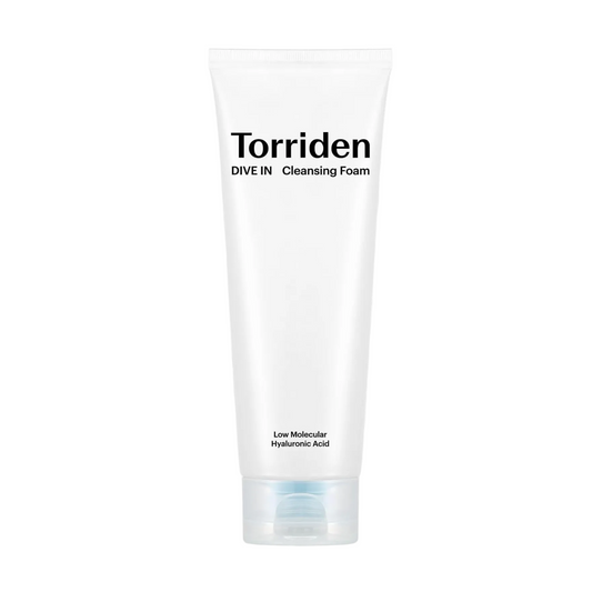 A white tube of Torriden Dive In Cleansing Foam centered on a white background with a large dollop of white foam behind it. The tube has black text reading 'Torriden' and 'DIVE IN Cleansing Foam' with smaller text near the bottom.