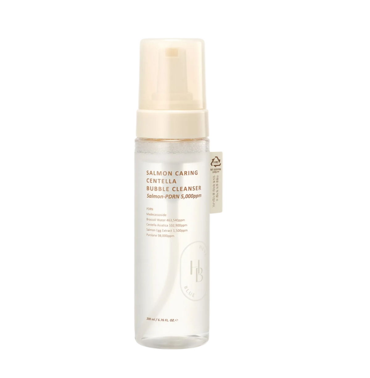 A bottle of Salmon Caring Centella Bubble Cleanser by L'Artisan du Bégumel, featuring a clear cylindrical bottle with a beige pump dispenser and a small beige tag, set against a light gray background.